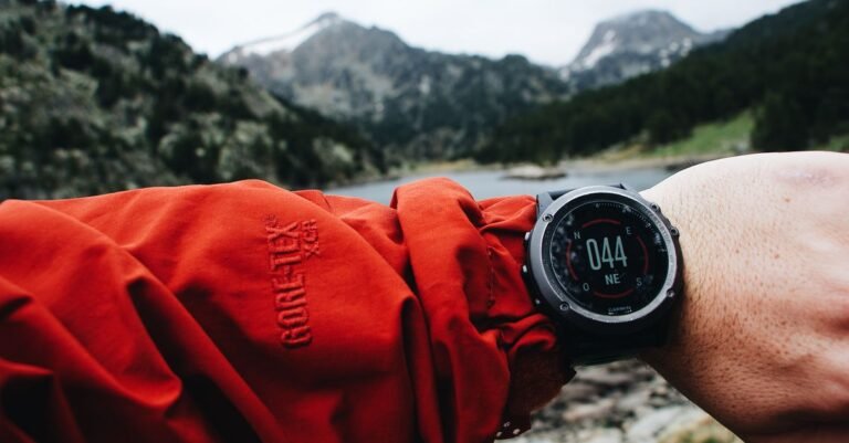 Randonneur consultant sa montre GPS dans un paysage de montagne