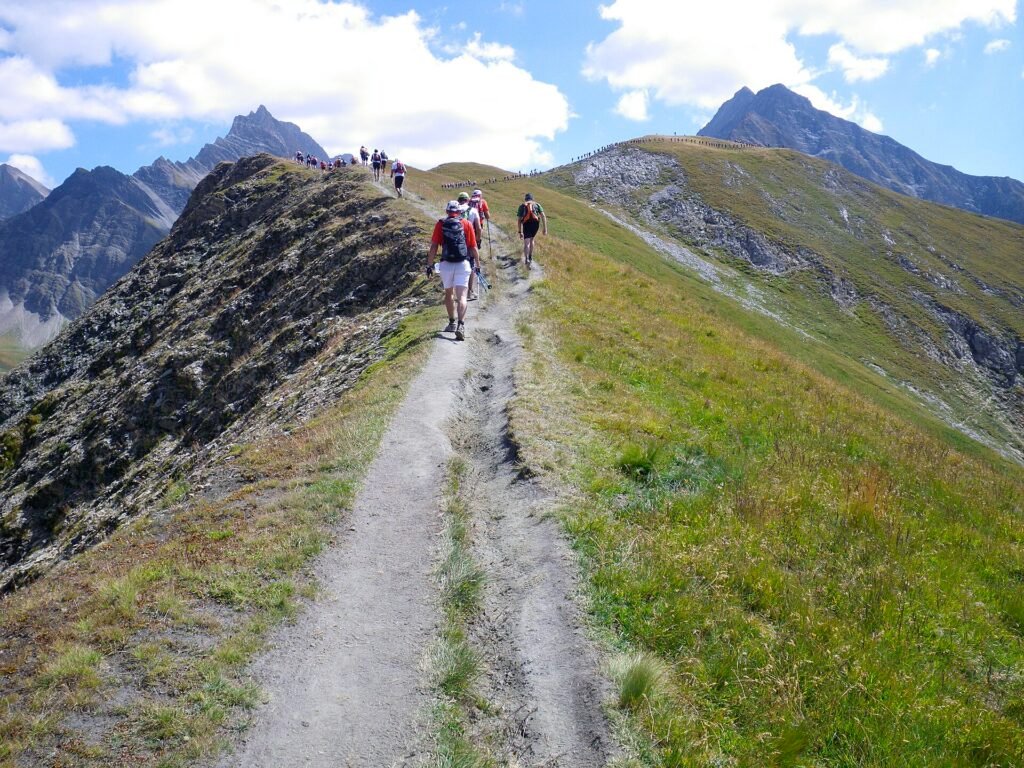 Coureurs de trail en montée en montagne avec leur sac contenant le matériel obligatoire