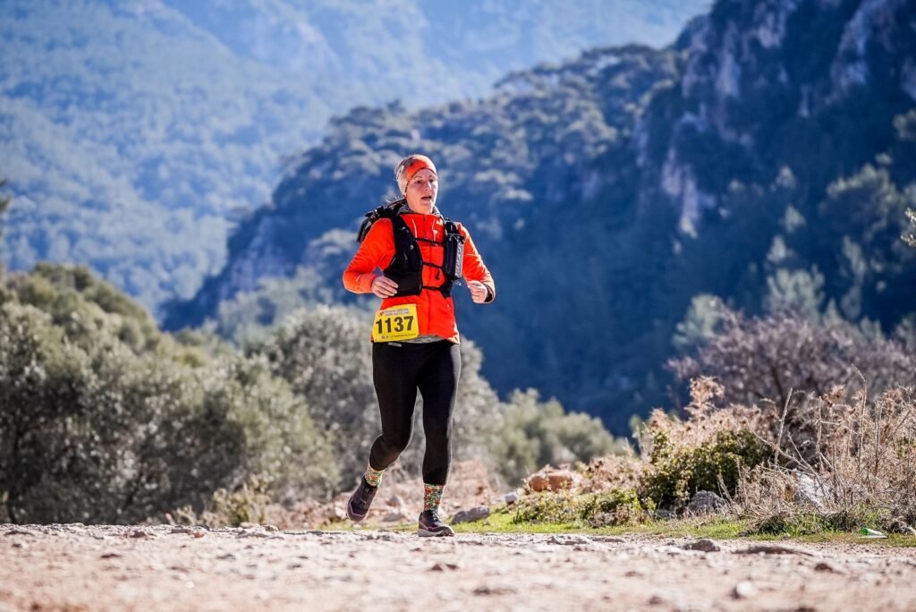 Coureur de trail equipe d'un gilet de portage sur un sentier de montagne