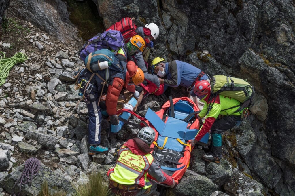 Équipe de secours en montagne prenant en charge un randonneur immobilisé sur un versant rocheux
