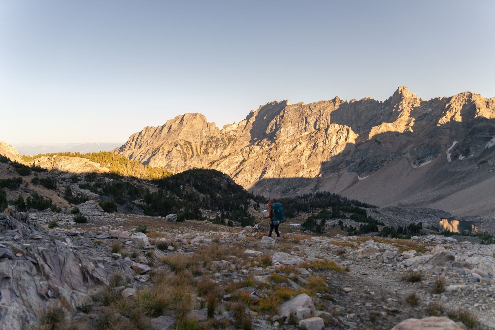 Coureur sur un sentier de montagne au lever du jour, sortie longue en autonomie
