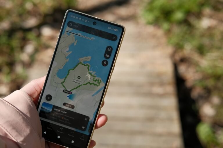Main tenant un smartphone qui affiche la carte et la trace d'un fichier GPX pendant une randonnee